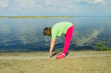 Woman exercise on the river bank