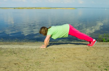 Woman exercise on the river bank