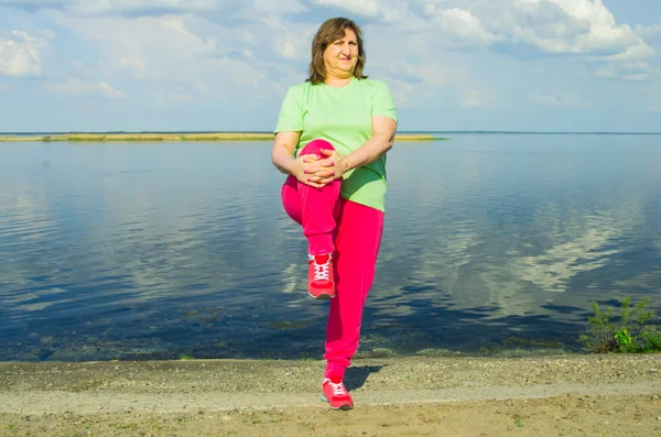 Woman exercise on the river bank