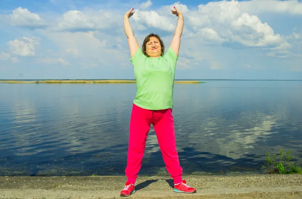 Woman exercise on the river bank