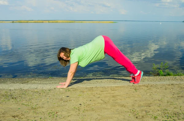 Woman exercise on the river bank