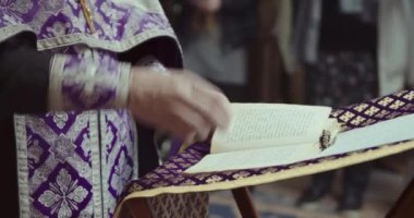 Ortodoks rahiplerin elleri haç yaptı ve İncil 'in sayfasını değiştirdi.