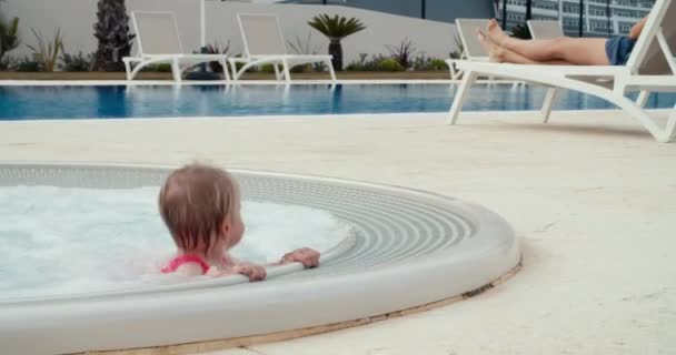 Mladá holčička skákání a baví venku jacuzzi na dovolené — Stock video