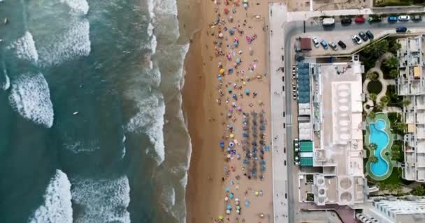 Drone voando sobre a praia de verão com vista para turistas e surfistas ondas — Vídeo de Stock