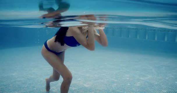 Mladá krásná žena plavání pod vodou v bazénu na jeho dovolené ve Španělsku — Stock video