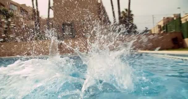 Щаслива дитина в літній день бігає і стрибає у блакитний прісний басейн воду і плаває — стокове відео