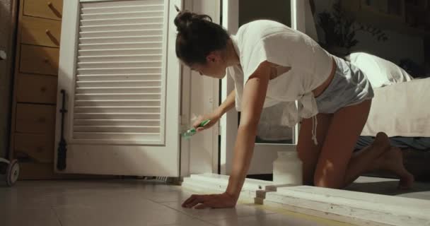 Jong sexy vrouw verf de houten deur met borstel doen diy huis reparatie — Stockvideo