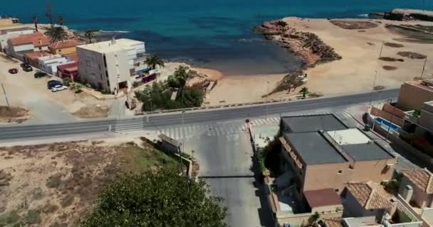Drone flaying above the street, ups camera approaching to the beach and blue sea — Stock video