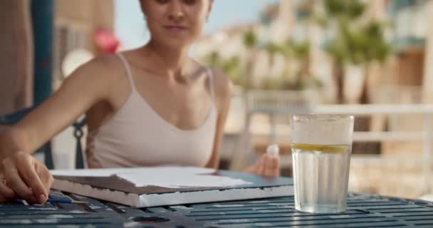 Beautiful young woman draws canvas outdoors and drink cold water with lemon — Stock Video