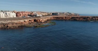 Sabahları mavi denizin mavi suları üzerinde uçar kıyıya bakan şehir boyunca.