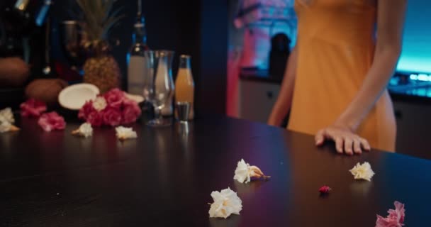 Close up chica en un vestido amarillo abre botellas en la mesa en una fiesta de noche en casa — Vídeos de Stock