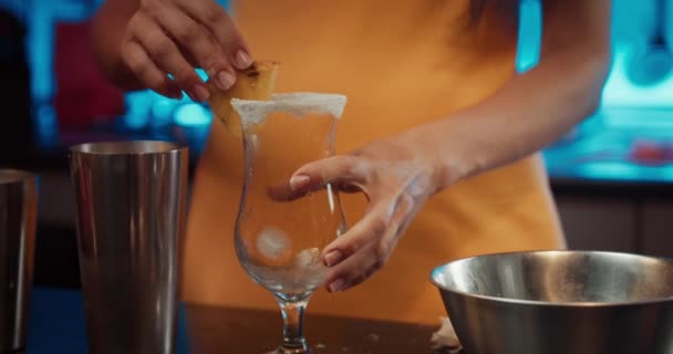 Închideți mâinile unei femei tinere turnând cocktail în sticlă și punând ananas — Videoclip de stoc