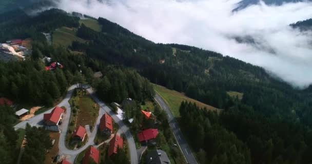 Lotnicze drony strzelanie gór okrytych lasami chmur i wsi — Wideo stockowe