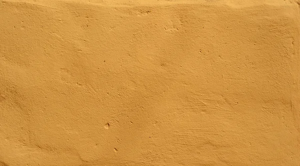 Textura da parede velha coberta com estuque amarelo — Fotografia de Stock