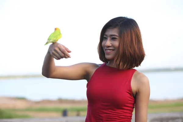 pretty woman pose and smile with green bird