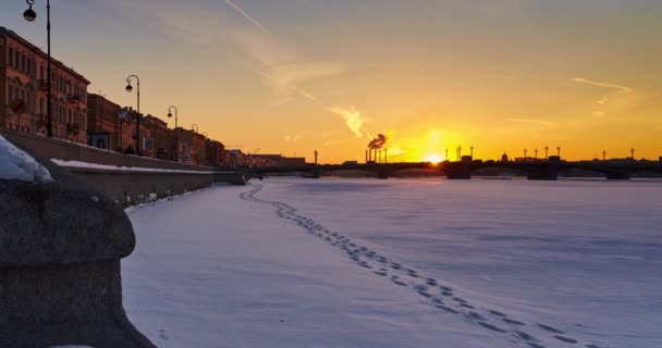 Rússia, São Petersburgo, 1 de março de 2016: Ponte Blagoveshchenskiy, Promenade des Anglais, pôr do sol de inverno, rio Neva coberto de neve, fumaça das chaminés ao fundo, tráfego, lapso de tempo 4k — Vídeo de Stock