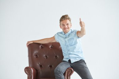 Oturan bir kahverengi deri koltuk, iletişim, müzakere, kısa kollu, acımasız, bir şık akıllı adam, küçük tıraşsız, karizmatik, mavi gömlek, portre saç modeli, duygular, enerji, faiz