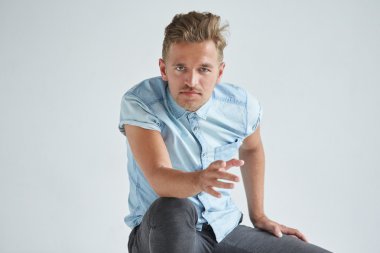 Acımasız adam yumruklarını sıktı, sandalyede oturan kısa kollu gömlekli hafifçe, diz, dalgın eğildi alın, bakışları altında eğildi