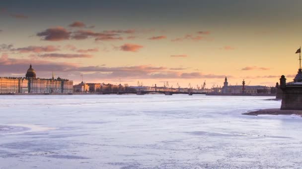 Rusia, San Petersburgo, 19 de marzo de 2016: La zona de agua del río Neva al atardecer, el Palacio de Invierno, el Puente del Palacio, la cúpula de la Catedral de San Isaac, nubes rosadas, río congelado — Vídeo de stock