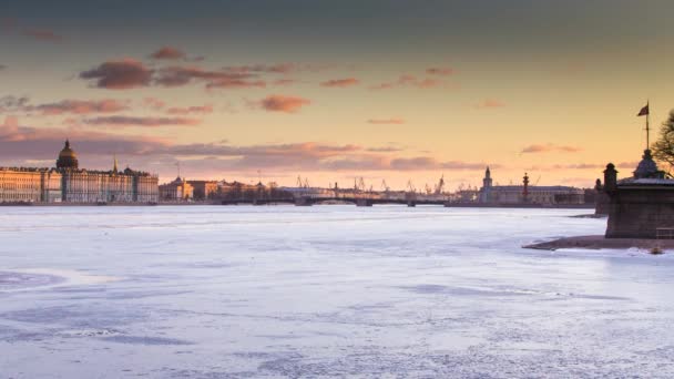 Russia, Saint-Petersburg, 19 March 2016: The water area of the Neva River at sunset, the Winter Palace, Palace Bridge, the dome of St. Isaac's Cathedral, pink clouds, frozen river — Stock Video