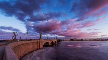 Rusya, Saint-Petersburg, 19 Mart 2016: pembe bulutlar üzerinde Troitsky sürüklenen köprüsünde, günbatımı, buz, donmuş Neva nehir, köprü üzerindeki trafik yaya yürüyerek Troitskiy