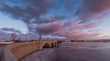 Rusya, Saint-Petersburg, 19 Mart 2016: pembe bulutlar üzerinde Troitsky sürüklenen köprüsünde, günbatımı, buz, donmuş Neva nehir, köprü üzerindeki trafik yaya yürüyerek Troitskiy