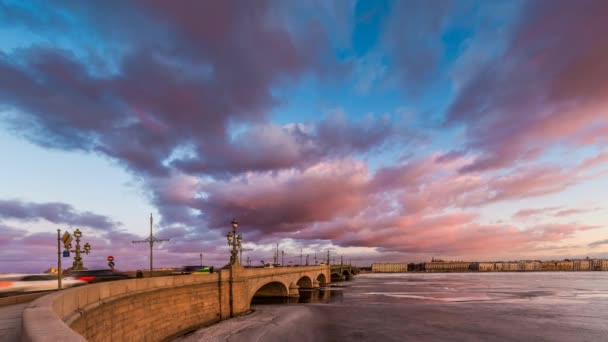 Rusko, Petrohrad, 19 březen 2016: růžové obláčky nad Troitsky most při západu slunce, plovoucí LED, zamrzlé řeky Něvy, provoz na mostě, pěší chůze, Troitskiy — Stock video
