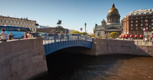 Ρωσία, Αγία Πετρούπολη, 08 Μαΐου 2016: Πανόραμα της πλατείας του Ισαάκ από τον ποταμό Μομόκα, τη γαλάζια γέφυρα, ένα μνημείο του Νικονάι, το ξενοδοχείο Astoria, μια κιονοστοιχία, πλοία, βάρκες, τουρίστες, μια κίνηση — Αρχείο Βίντεο