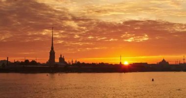 Rusya, Saint-Petersburg, 29 Haziran 2016: sunrise, hızlandırılmış Peter ve Paul Fortress sessiz dalgalar nehir Neva, melek kule, pembe ve turuncu gökyüzü, etkisi zoom ile altın bir kulenin