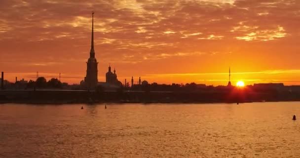 Ryssland, St Petersburg, 29 juni 2016: Time-lapse The Peter och Paul Fortress vid soluppgången, tystnaden vågor floden Neva, en gyllene spira med ängel på tornet, rosa och orange himmel, zoomeffekt — Stockvideo
