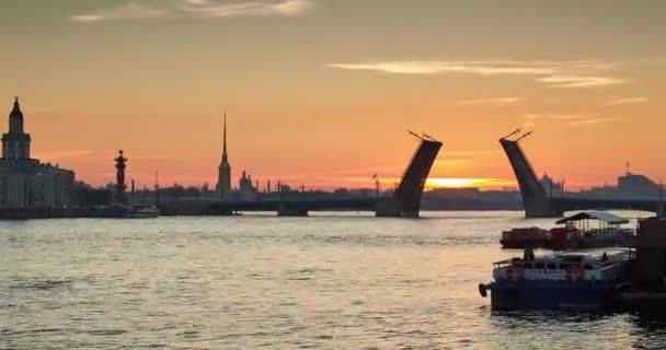 Rosja, Sankt-Petersburg, 03 lipca 2016: upływ czasu zamknięcia Palace Bridge o wschodzie słońca, Piotr i Paweł twierdzy kolec w pomarańczowe niebo, rostralnego słupem, statki, łodzie, na początku ruchu — Wideo stockowe