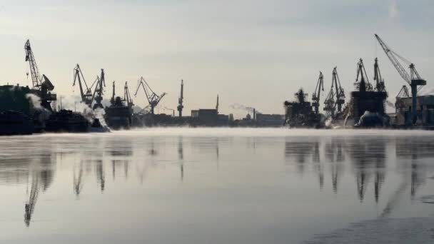 Östersjövarvets kranar en kylig vinterdag, ånga över floden Neva, slät flodyta, spegelreflektion över vattnet, fartyg under uppbyggnad, trålare, isbrytare — Stockvideo