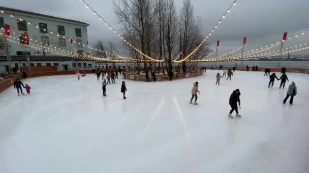 러시아, 상트페테르부르크, 2021 년 1 월 28 일: 스케이트장, 스케이트장, 음산 한 날씨, 음악 재생, 자녀와 행복 한 부부가 있는 가정 — 비디오