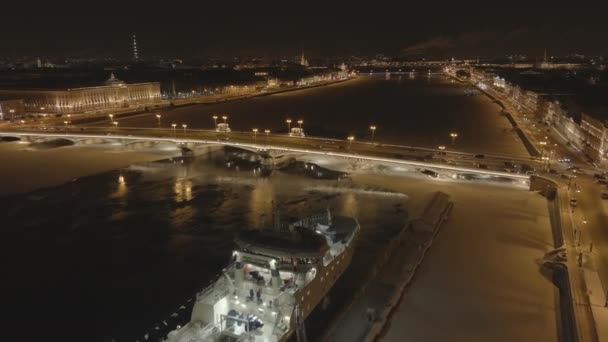 Russland, Sankt-Petersburg, 2. Februar 2021: Luftaufnahmen der Winternachtstadt, Blagoweschtschenko-Brücke, Vorbeiflug über das Fischereischiff, die Brücke des Leutnants Schmidt, die Palastbrücke — Stockvideo