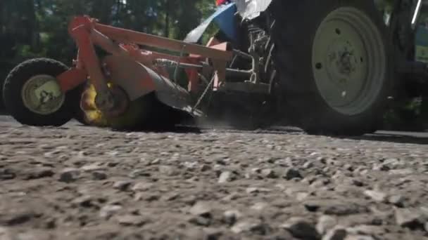 Russia, St.Petersburg, 28 June 2019: Roadwork on asphalt replacement, the car for removal of old asphalt, the conveyor, the road in the wood, a summer sunny day, special equipment — Stock Video