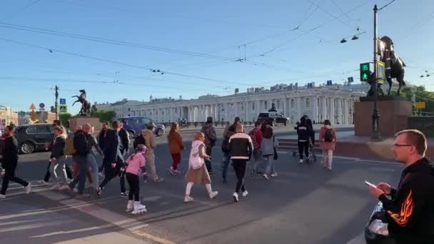 俄罗斯圣彼得堡，2020年6月2日：著名的四匹马的Anichkov桥，Covid-19病毒大流行时的Nevsky Prospect建筑，人们穿过马路，长长的阴影 — 图库视频影像
