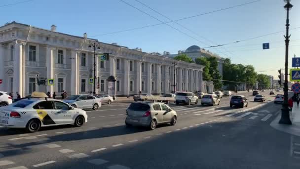 Russia, San Pietroburgo, 02 giugno 2020: L'architettura della Prospettiva Nevsky al tramonto durante la pandemia del virus Covid-19, il teatro delle marionette, molti mezzi di trasporto, lunghe ombre di persone e auto — Video Stock