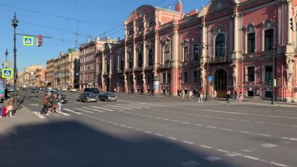 Rusya, St.Petersburg, 02 Haziran 2020: Covid-19 virüsü salgını sırasında Nevsky Prospect 'in mimarisi, Anichkov Sarayı ve köprüsü cephesi, ulaşım araçları, uzun gölgeler — Stok video