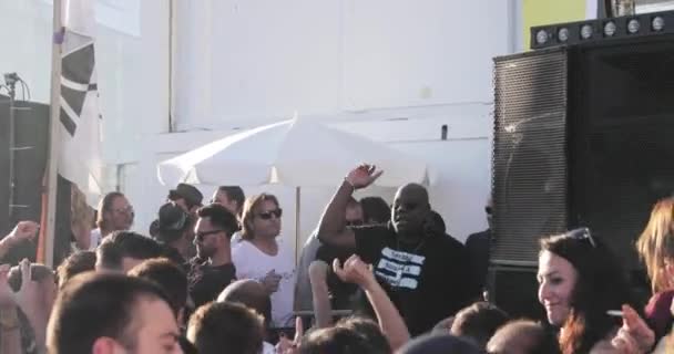 Frankrijk, Cannes, 19 mei 2017: het feest op een strand met veel mensen, de DJ de vader van een techno Carl Cox speelt op 4 draaitafels, handen omhoog, zonsondergang, zee en bergen op de achtergrond — Stockvideo