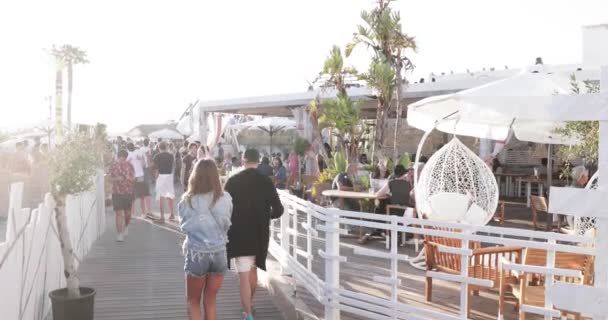 Prancis, Cannes, 19 Mei 2017: pesta di pantai dengan banyak orang, DJ ayah dari seorang tekno Carl Cox bermain di 4 meja putar, tangan ke atas, matahari terbenam, laut dan gunung di latar belakang — Stok Video