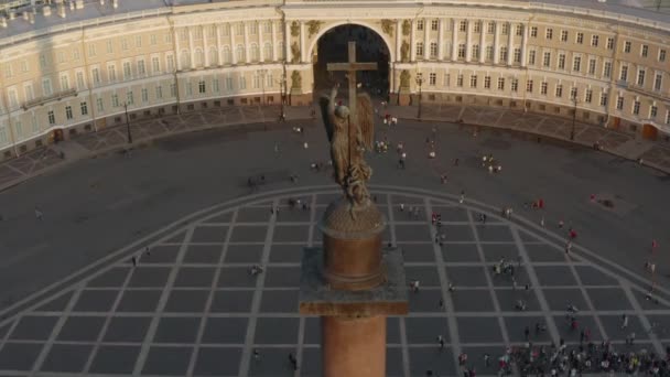 Aerial view of Palace Square and Alexander Column at sunset, The angel on a clone rises up, The drone falls downthe Winter Palace, the Hermitage, triumphal chariot, little people walks, — Stock Video