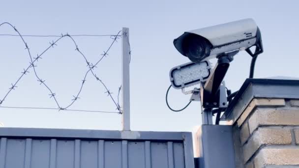 Russia, St.Petersburg, 22 March 2021: The surveillance camera on a metal fence with a barbed wire, led illumination — Stock Video