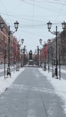Dünyaca ünlü yazar Gogol Nikolay Vasilyevich 'in St. Petersburg' daki Malaya Konyushennaya Caddesi 'ndeki kış manzarası, sokak lambalarından umut ışığı, bulutlu hava, kar yağıyor, dikey