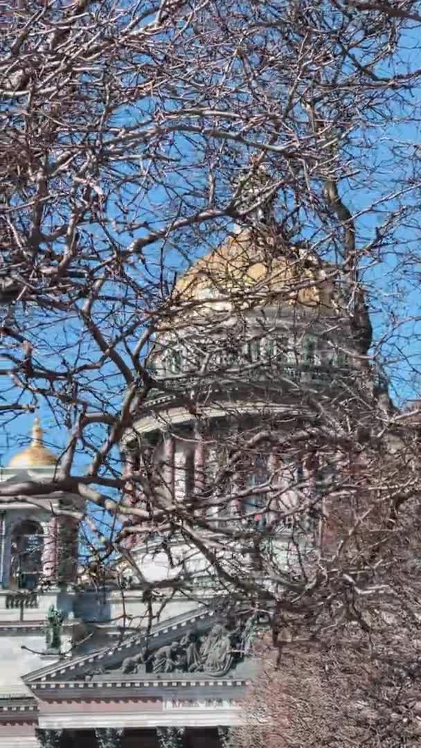 Vertical footage of Colonnade of St. Isaacs Cathedral through branches of trees without leaves in the sunny weather, the first sunny days of spring, slow motion — Stock Video