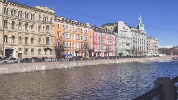 Rusia, San Petersburgo, 01 Abril 2021: Pintoresco paisaje del terraplén del río Moyka en un clima soleado, la construcción del centro comercial En el puente rojo — Vídeo de stock