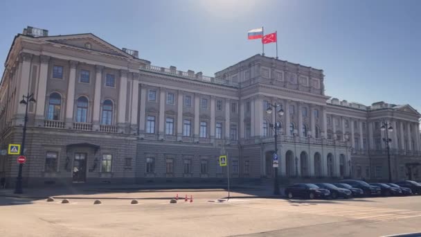 2021年4月1日，圣彼得堡：在阳光明媚的天气里，立法院大楼的城市景观，国家旗帜迎风飘扬，是一个美丽的复古风格的立面 — 图库视频影像