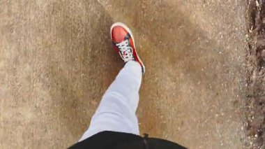 Kahverengi erkek çizmeleri güneşli bir günde parka gider, spor ayakkabılar, bağcıklı botlar, beyaz renkli pantolonlar, üst manzara, kapat, koyu renk ceket