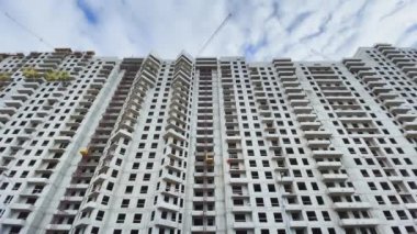 Rusya, St.Petersburg, 03 Nisan 2021: Yüksek katlı evin inşaatı, inşaat vinçleri, alttaki görüntü, video kameranın yavaş hareketi, penceresiz beton bloklar, büyük gayrimenkul