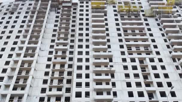 Rosja, Petersburg, 03 kwietnia 2021 r.: Budowa domu na wysokim piętrze, żurawie budowlane, widok z dołu, powolny ruch kamery wideo, bloki betonowe bez okien, ogromna nieruchomość — Wideo stockowe