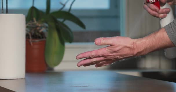 Ο άνθρωπος καθαρίζει τα χέρια με απολυμαντικό πιέζοντας το σπρέι μπουκαλιού, ρολό από χαρτοπετσέτες, απολύμανση του δέρματος των χεριών κατά τη διάρκεια της πανδημίας coronavirus, επιδημία COVID-19. Καταπολέμηση της εξάπλωσης του ιού — Αρχείο Βίντεο